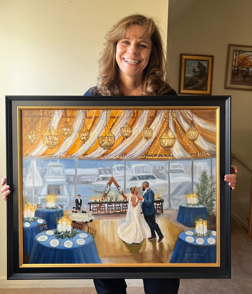 linda marino artist live painter holding wedding painting in black frame
